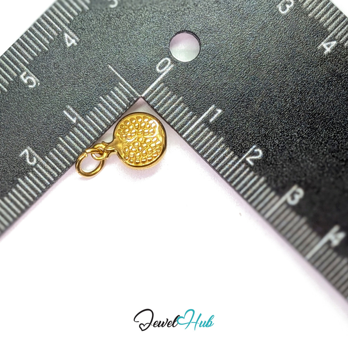 Pomegranate charm measured against a ruler at 10mm wide by 13.7mm tall - JewelHub