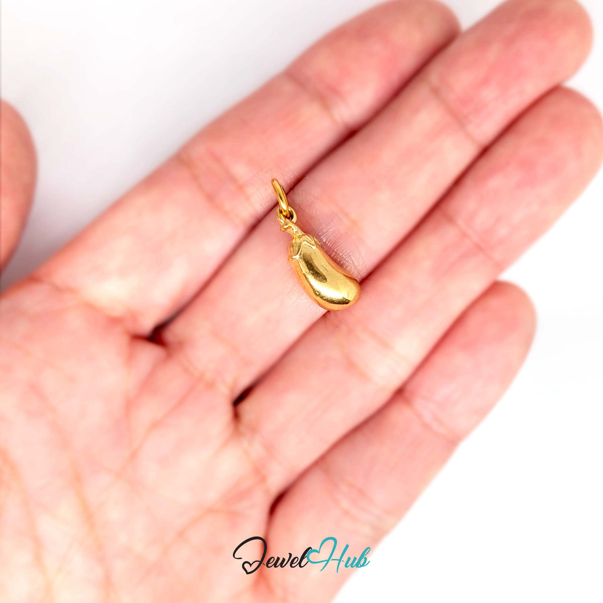 Aubergine charm held in a hand to show its size - JewelHub