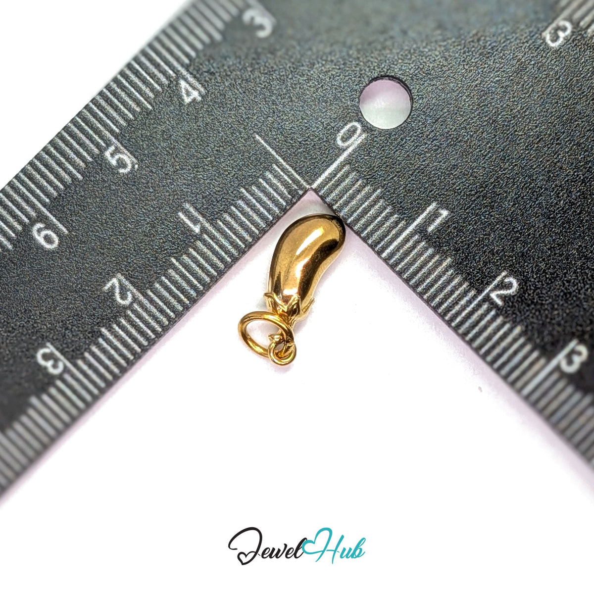 Aubergine charm measured against a ruler at 5.8mm wide by 16.4mm tall - JewelHub