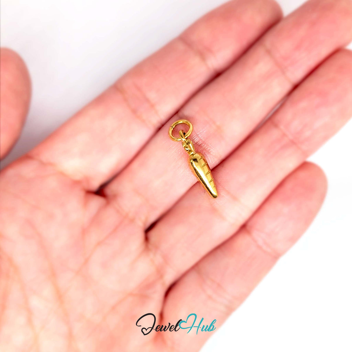 Mini carrot charm held in a hand to show its size - JewelHub