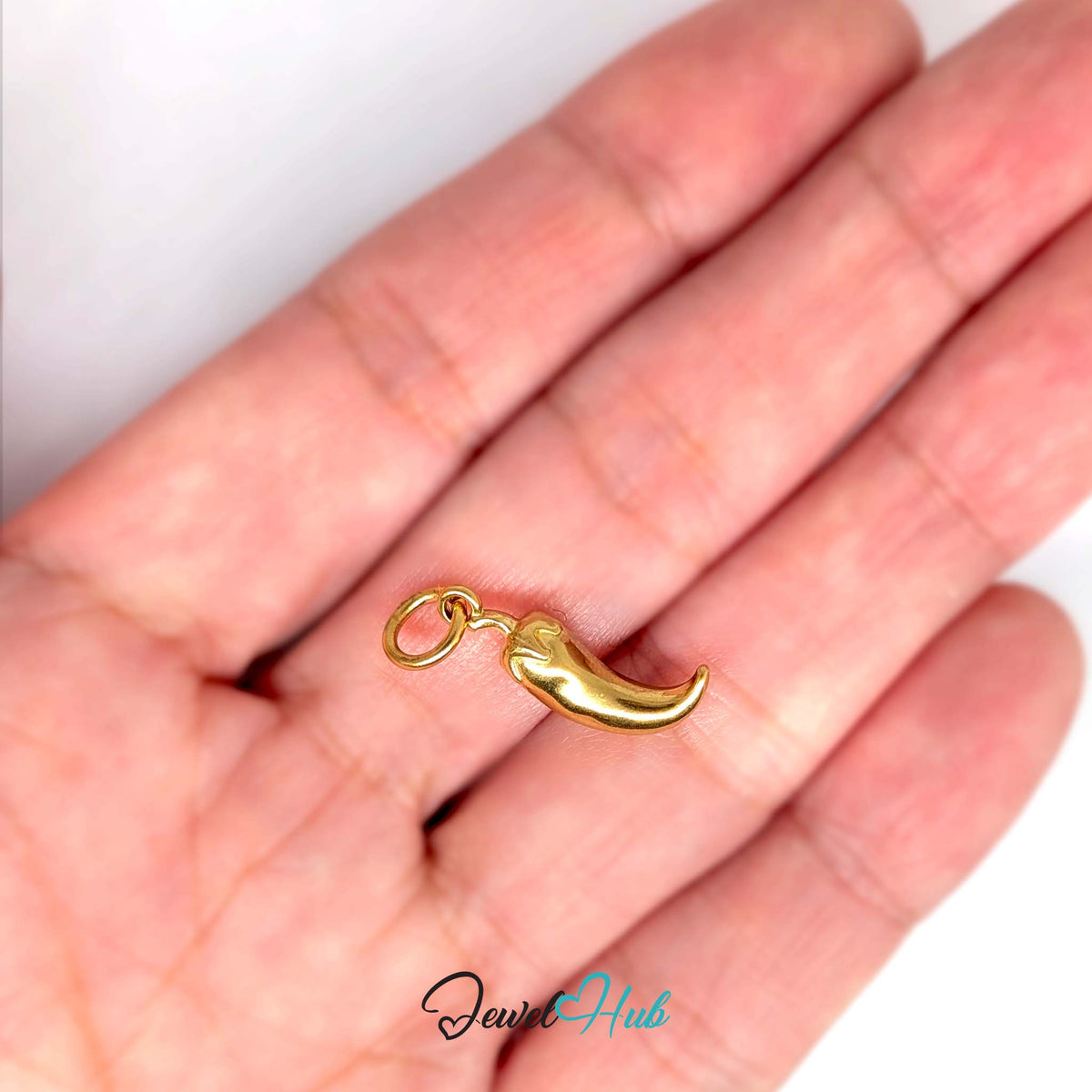 Curved chilli pepper charm held in a hand to show its size - JewelHub