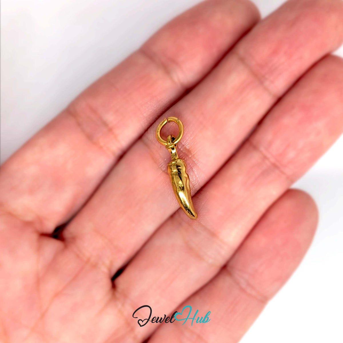 Mini chilli pepper charm held in a hand to show its size - JewelHub