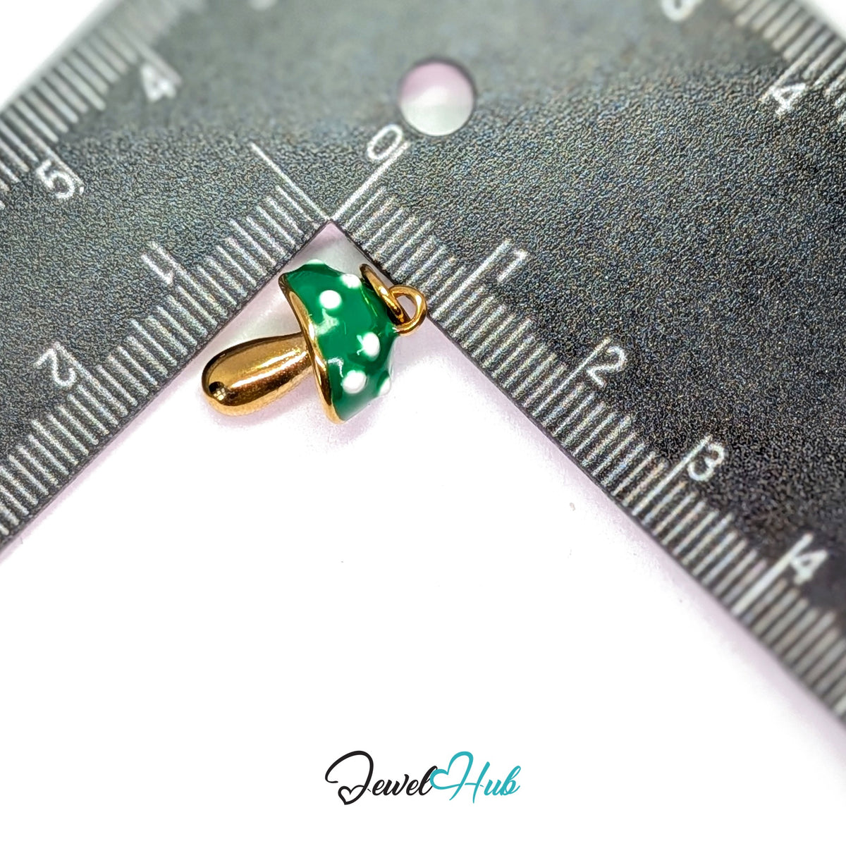 Green spotted mushroom charm measured against a ruler at 11.6mm wide by 17.3mm tall - JewelHub