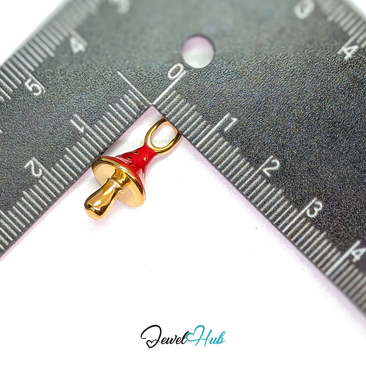 Red gold dot mushroom charm measured against a ruler at 10.7mm wide by 22.5mm tall - JewelHub