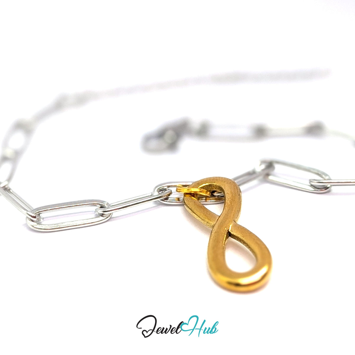 Gold-tone infinity charm styled on a silver paperclip chain bracelet for a two-tone look - JewelHub