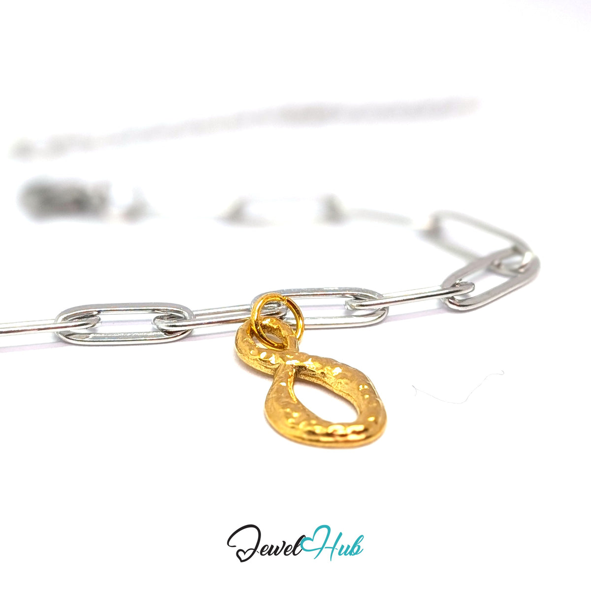 Gold-tone textured infinity charm styled on a silver paperclip chain bracelet for a two-tone look - JewelHub
