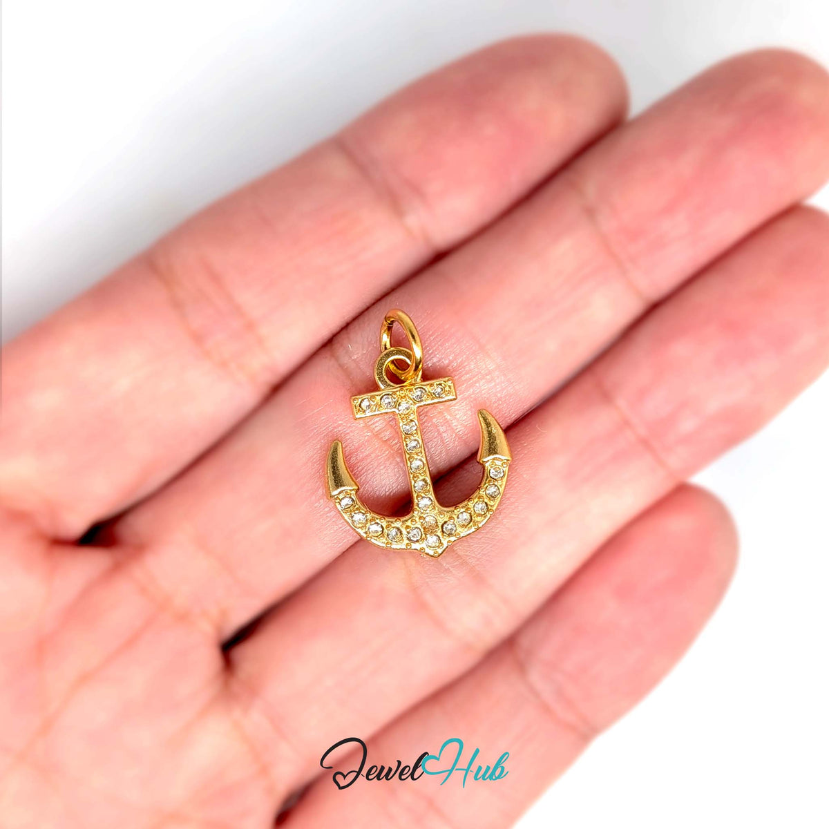 Crystal anchor charm held in a hand to show its size - JewelHub