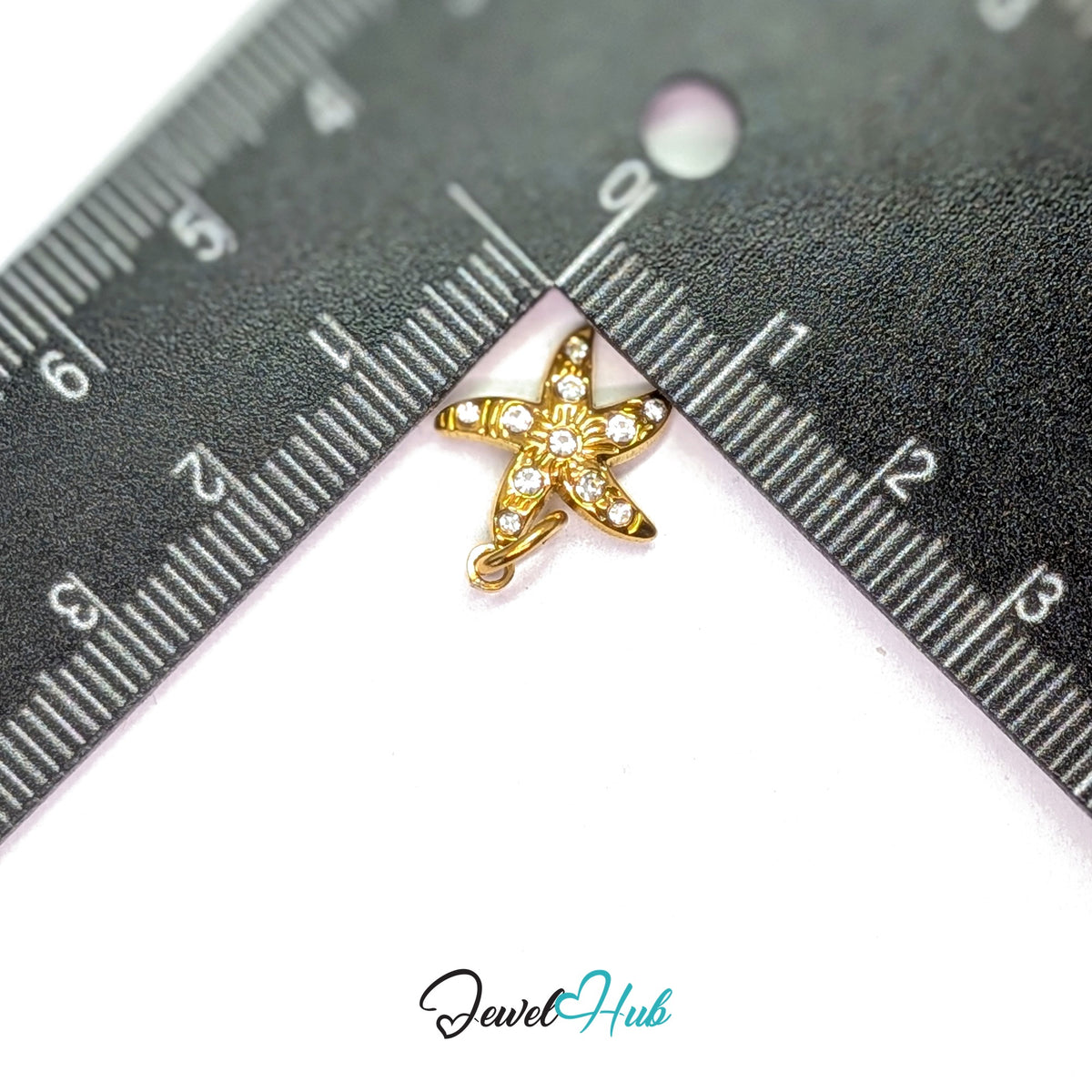 Crystal starfish charm measured against a ruler at 14mm wide by 15.7mm tall - JewelHub