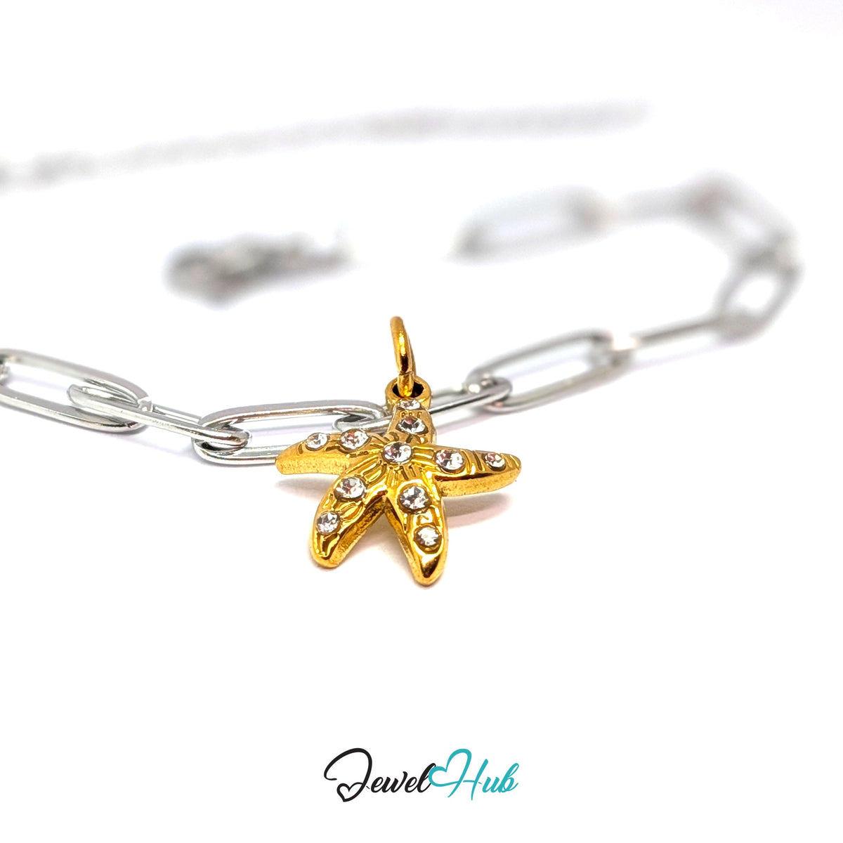 Gold-tone crystal starfish charm styled on a silver paperclip chain bracelet for a two-tone look - JewelHub