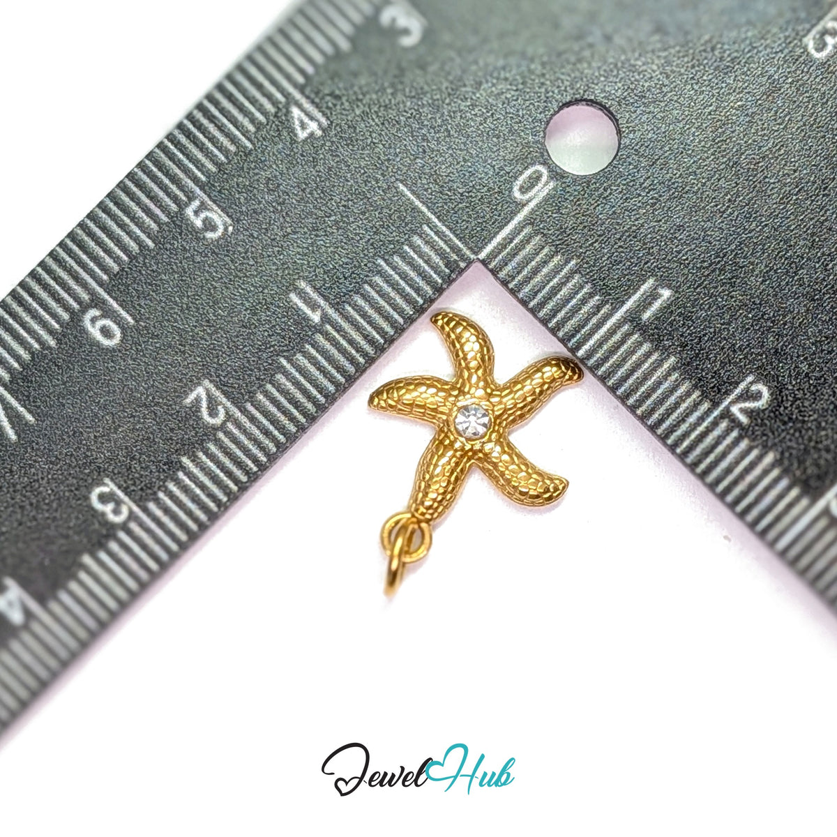 Textured starfish charm measured against a ruler at 16mm wide by 19.8mm tall - JewelHub