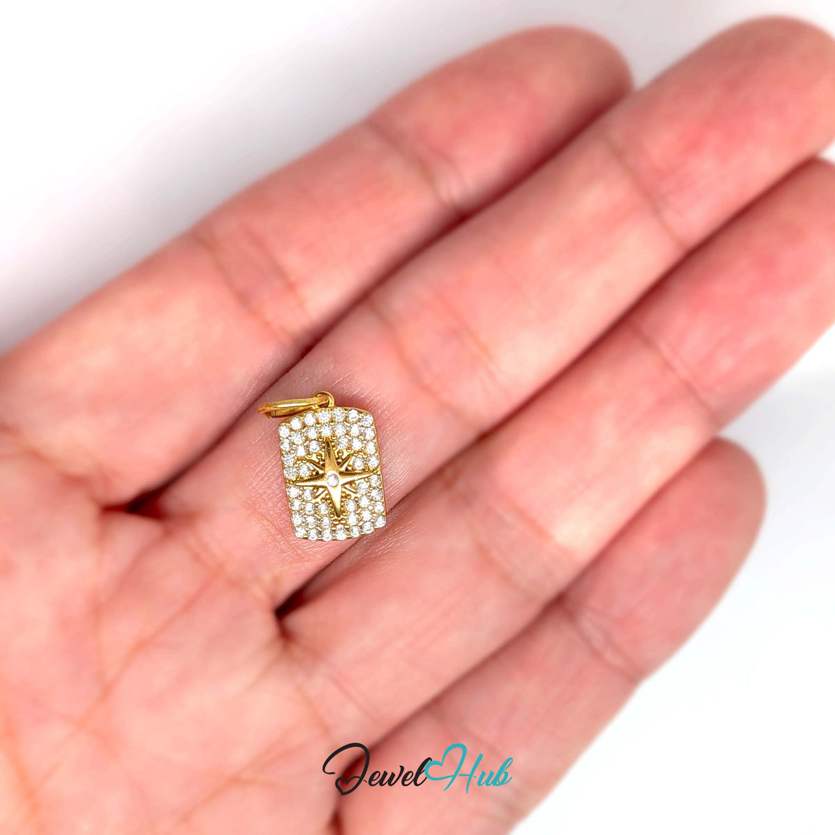 Crystal star tag charm held in a hand to show its size - JewelHub