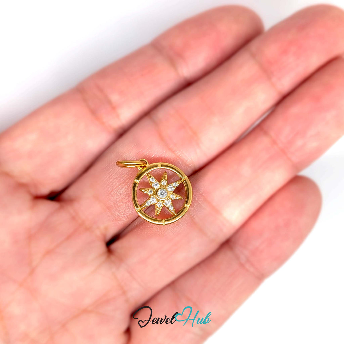Crystal star compass charm held in a hand to show its size - JewelHub