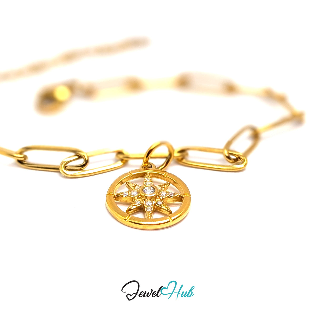 Gold-tone crystal star compass charm styled on a gold paperclip chain bracelet - JewelHub