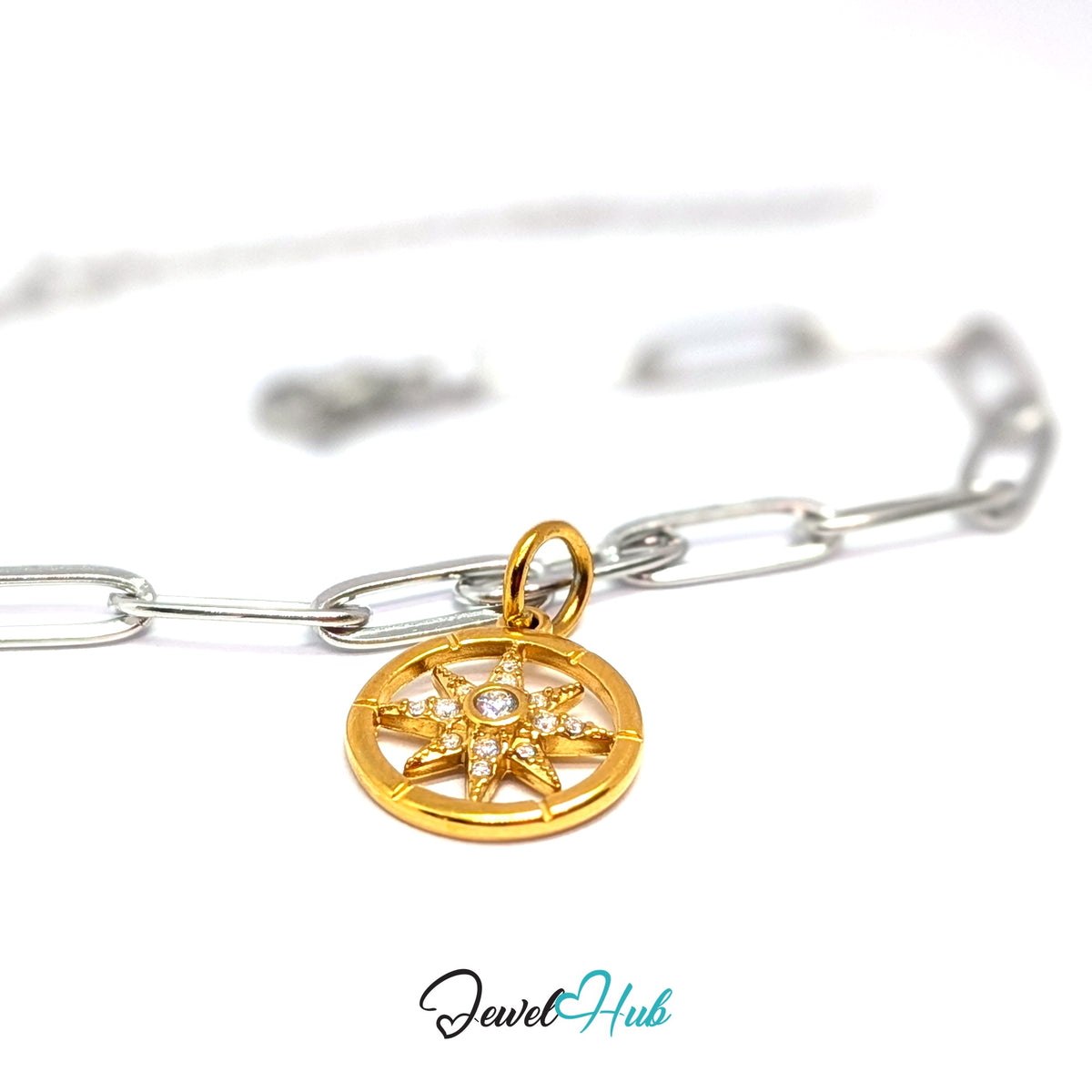 Gold-tone crystal star compass charm styled on a silver paperclip chain bracelet for a two-tone look - JewelHub