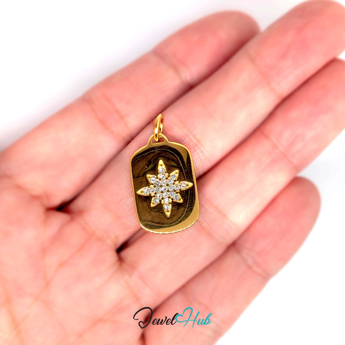 Crystal star plate charm held in a hand to show its size - JewelHub