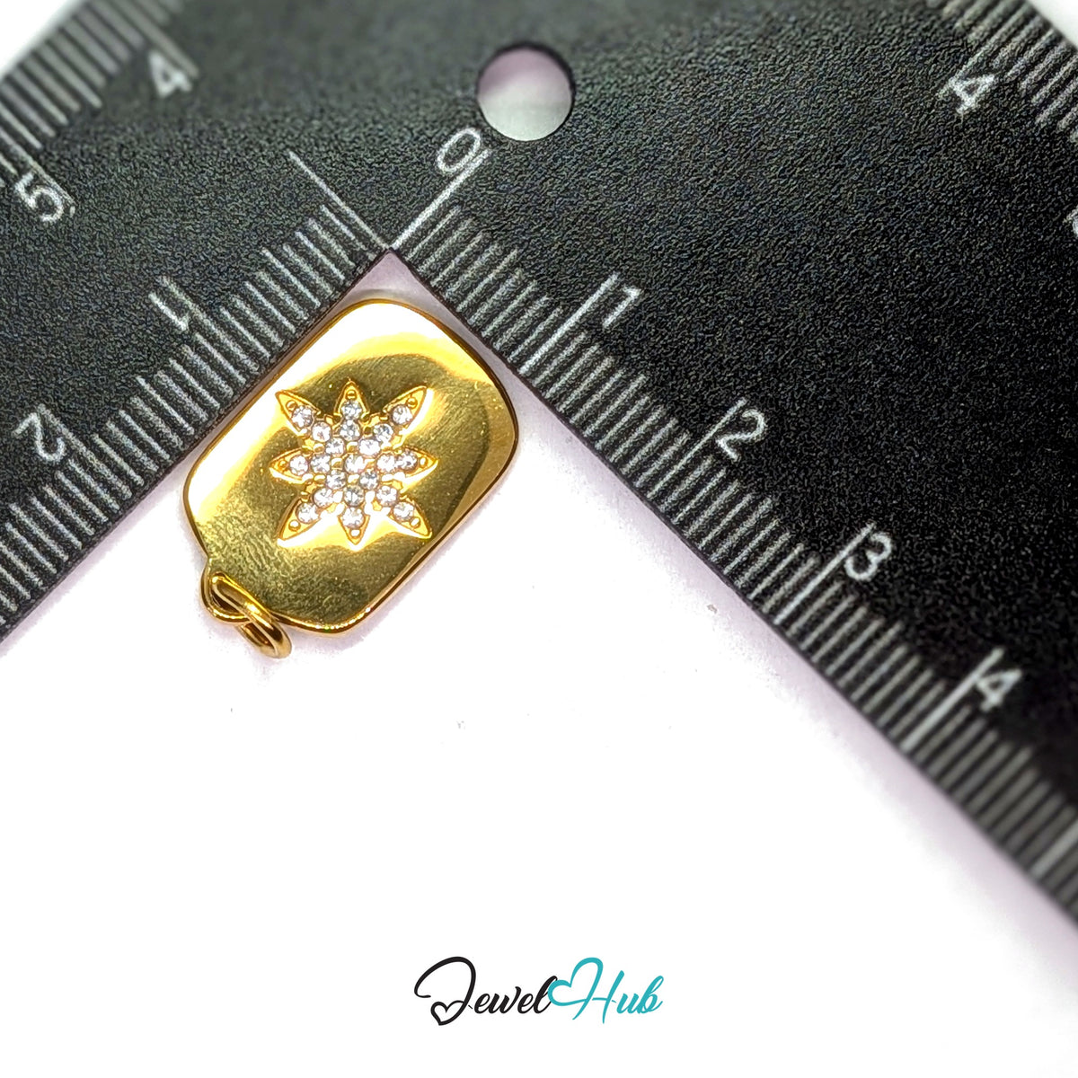 Crystal star plate charm measured against a ruler at 13.6mm wide by 24.2mm tall - JewelHub