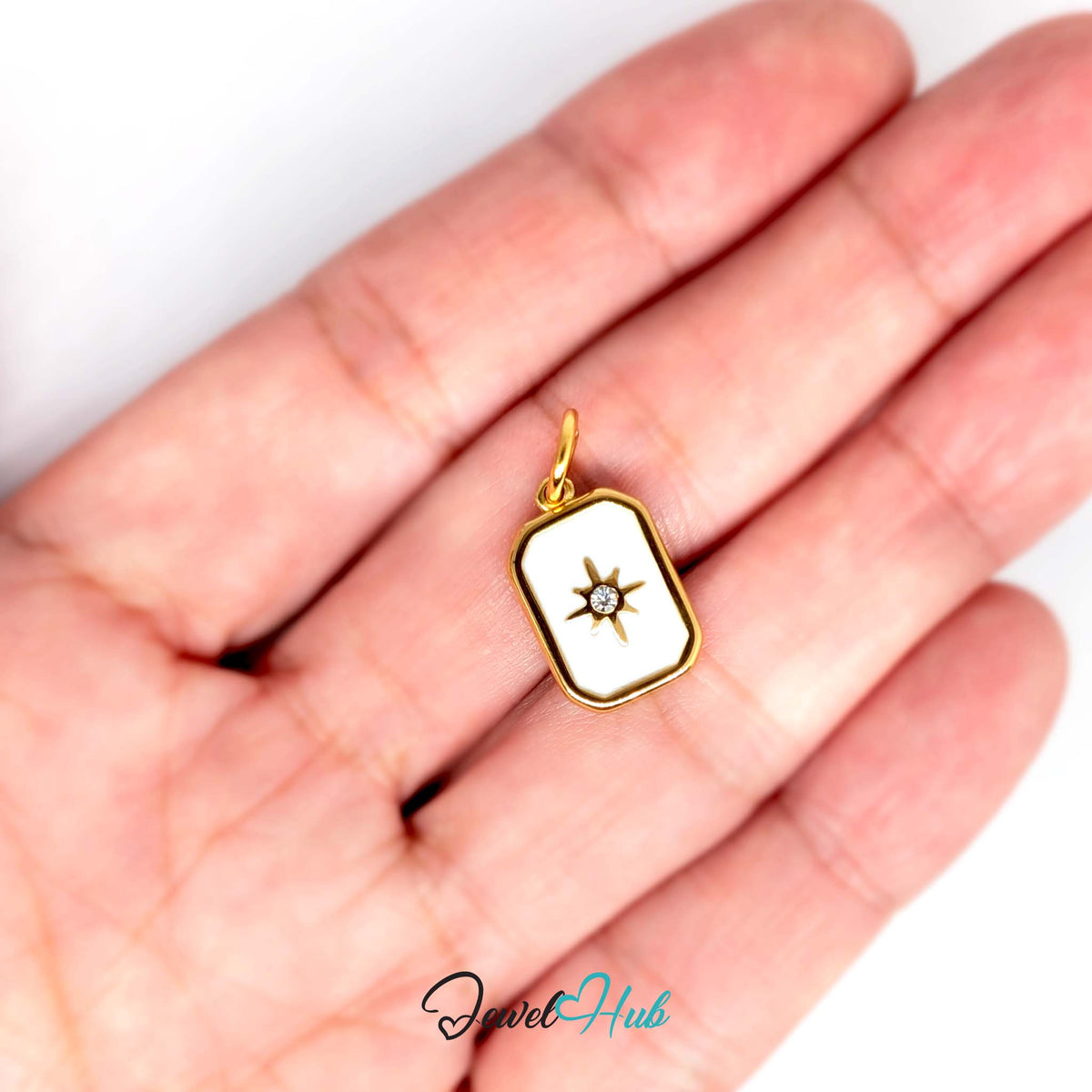 White star tag charm held in a hand to show its size - JewelHub