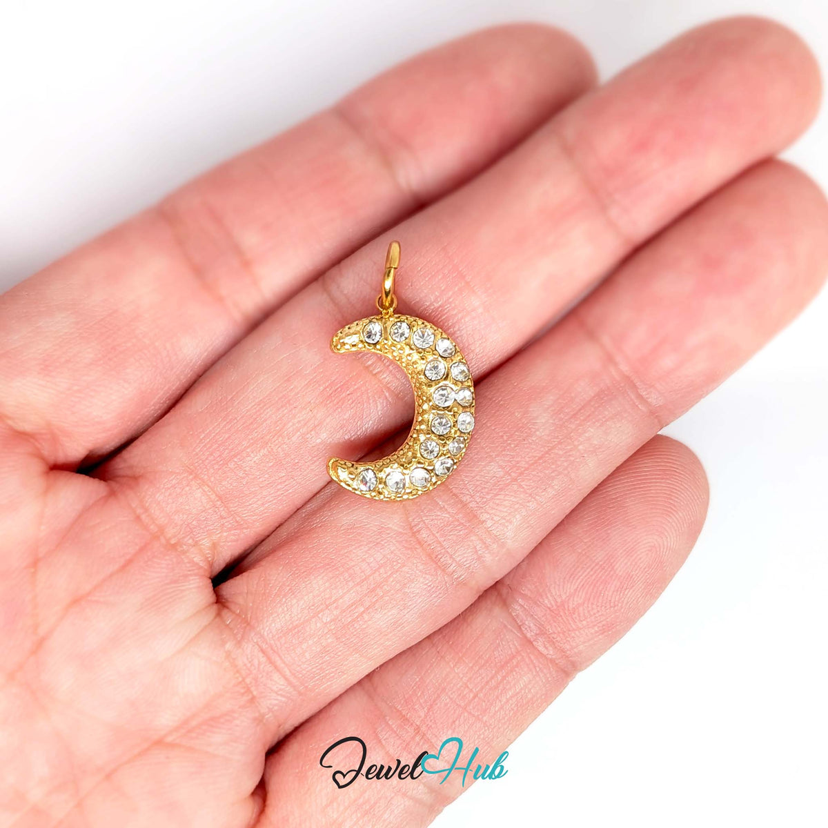 Crystal moon charm held in a hand to show its size - JewelHub