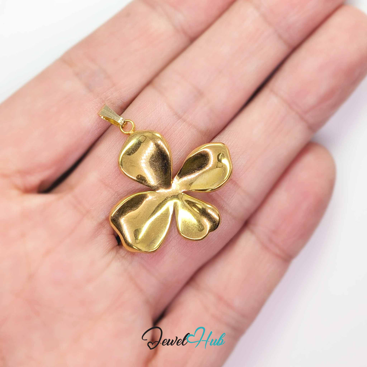 Gold Wavy Four Petal Flower pendant in gold-tone stainless steel - held in the hand to show size - JewelHub