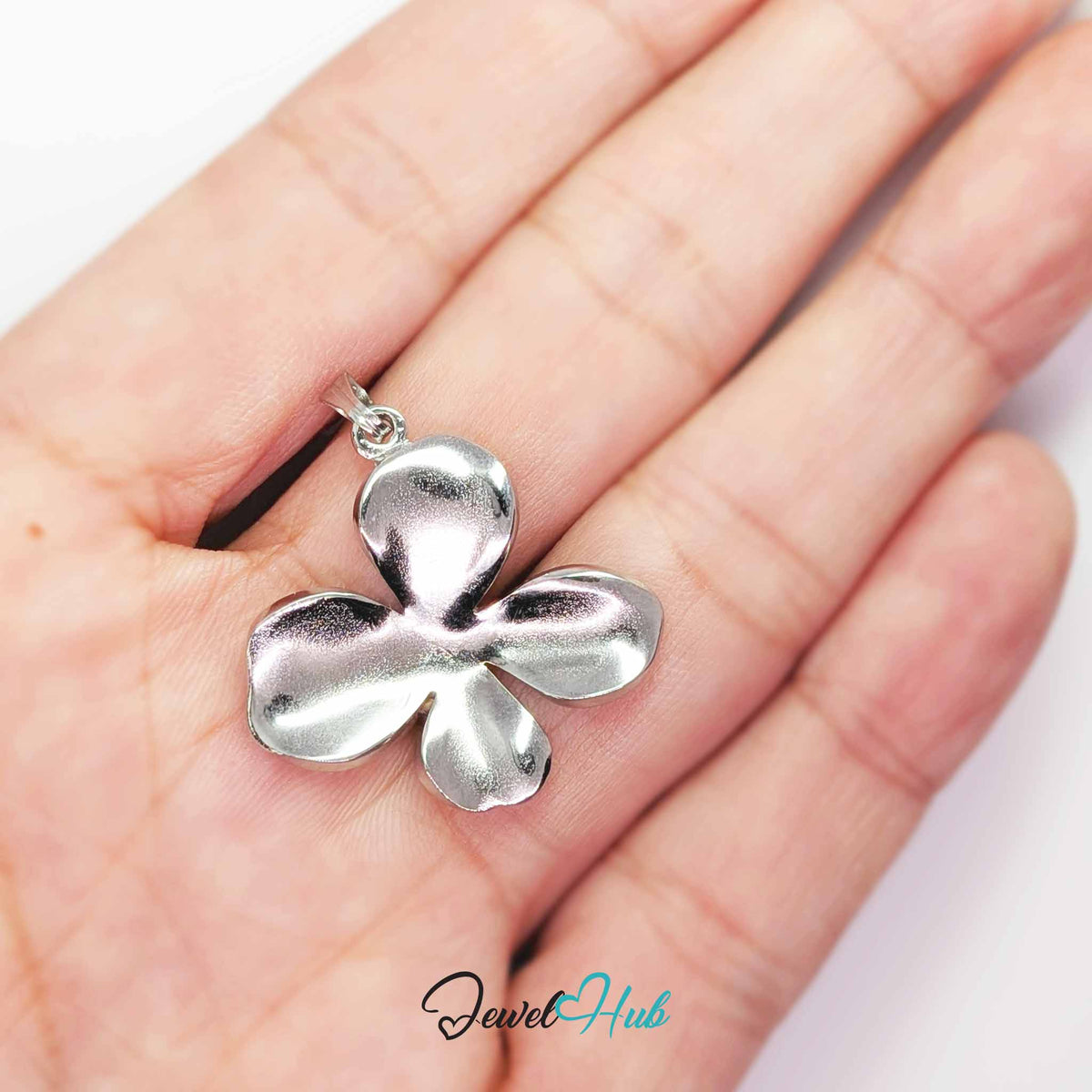 Silver Wavy Four Petal Flower pendant in silver-tone stainless steel - held in the hand to show size - JewelHub