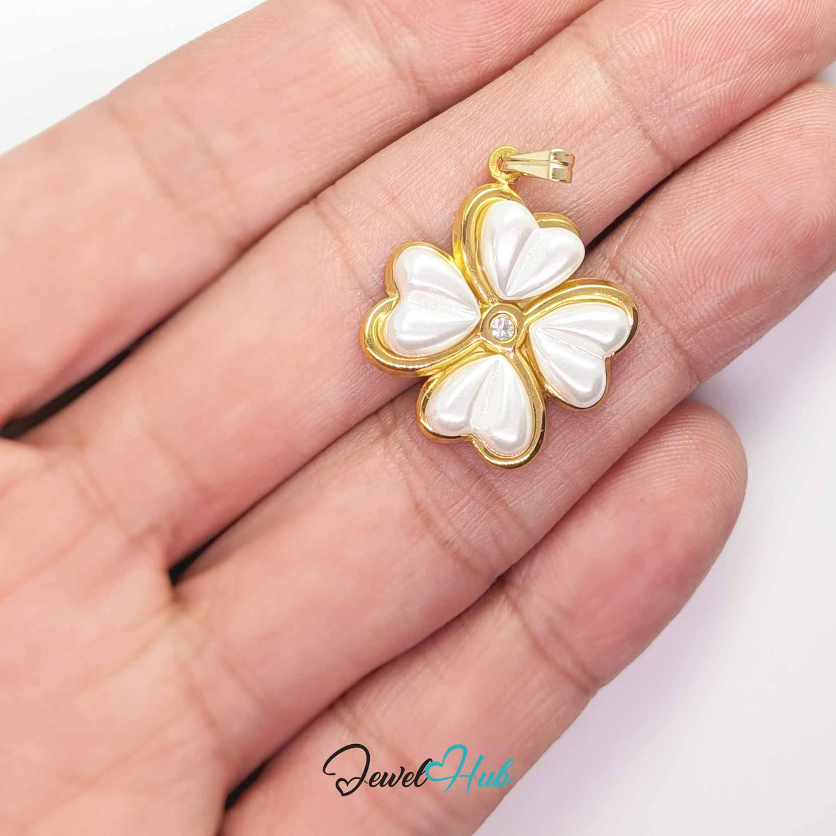 Pearl Four Leaf Clover pendant in gold-tone stainless steel - held in the hand to show size - JewelHub