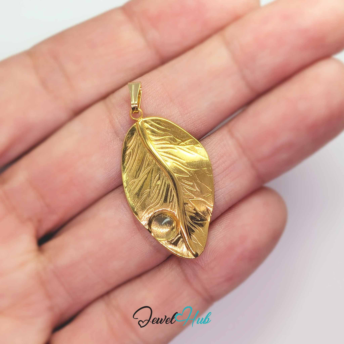 Gold Dewdrop Leaf pendant in gold-tone stainless steel - held in the hand to show size - JewelHub