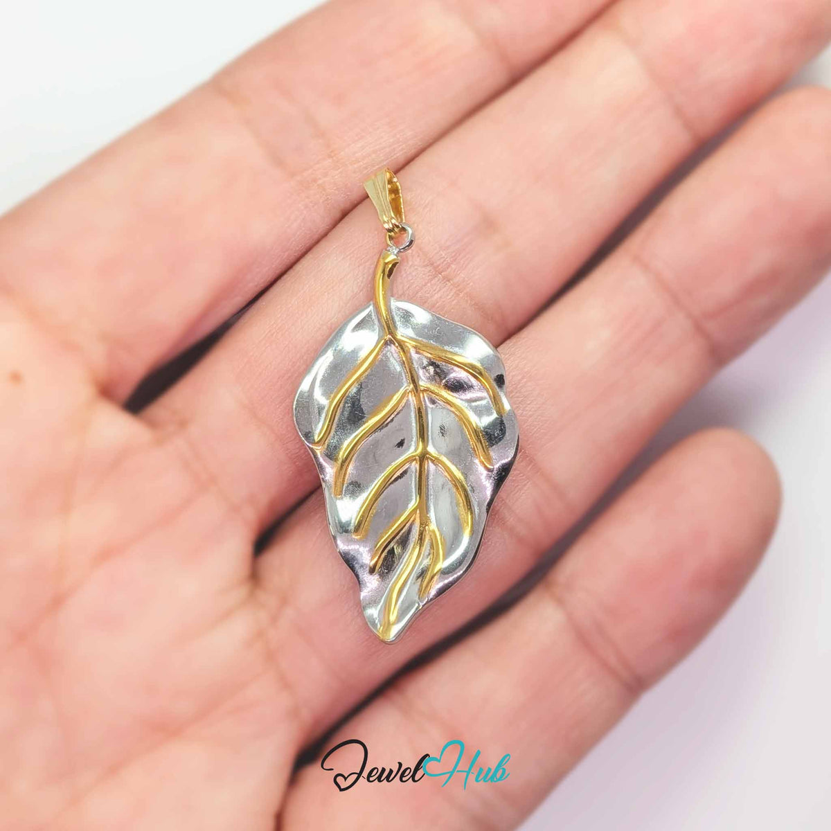Leaf pendant in DuoTone stainless steel - held in the hand to show size - JewelHub
