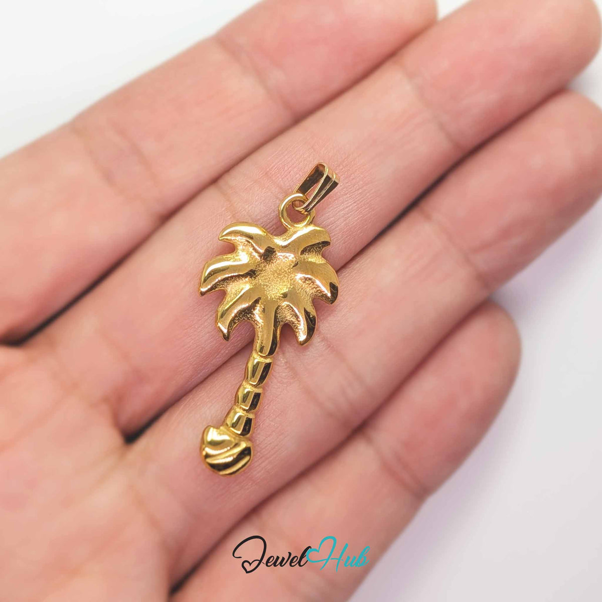 Gold Palm Tree pendant in gold-tone stainless steel - held in the hand to show size - JewelHub