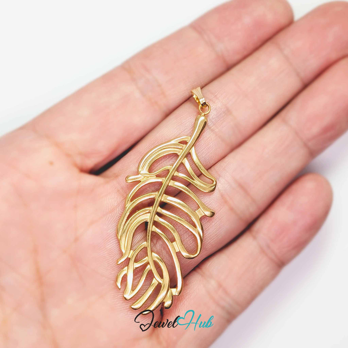Gold Feather Leaf pendant in gold-tone stainless steel - held in the hand to show size - JewelHub