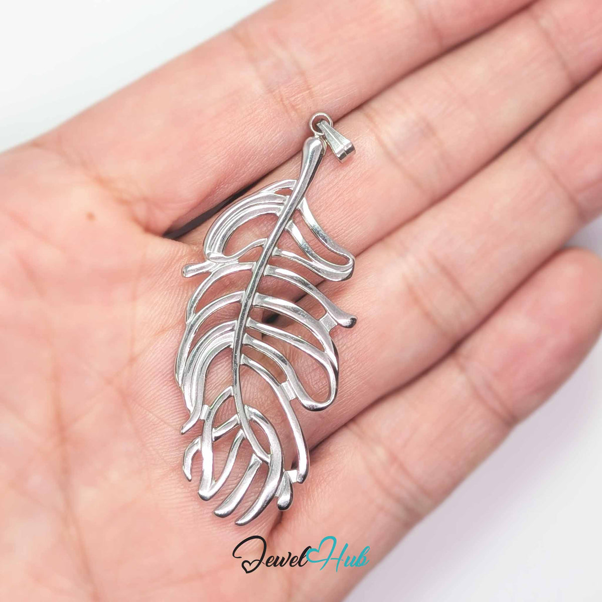 Silver Feather Leaf pendant in silver-tone stainless steel - held in the hand to show size - JewelHub