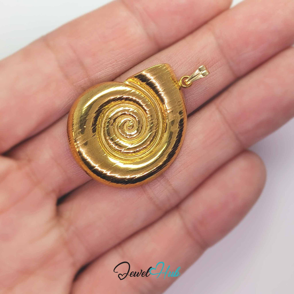 Gold Spiral Shell pendant in gold-tone stainless steel - held in the hand to show size - JewelHub