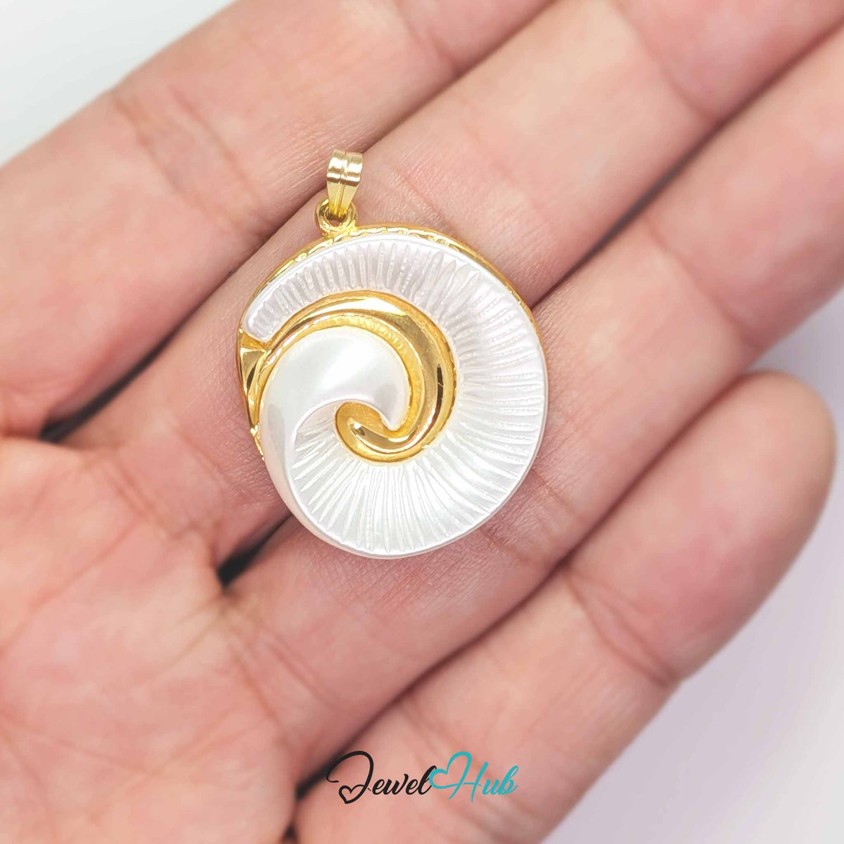 Pearl Spiral Shell pendant in gold-tone stainless steel - held in the hand to show size - JewelHub