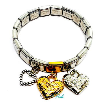 Silver bracelet with gold heart and padlock charms on a white background