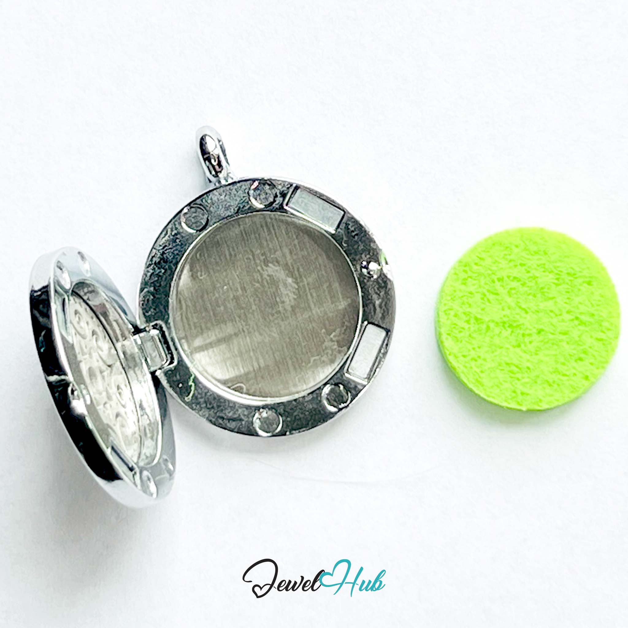 Silver locket with a green round object on a white background, branded 'Jewel Hub'.