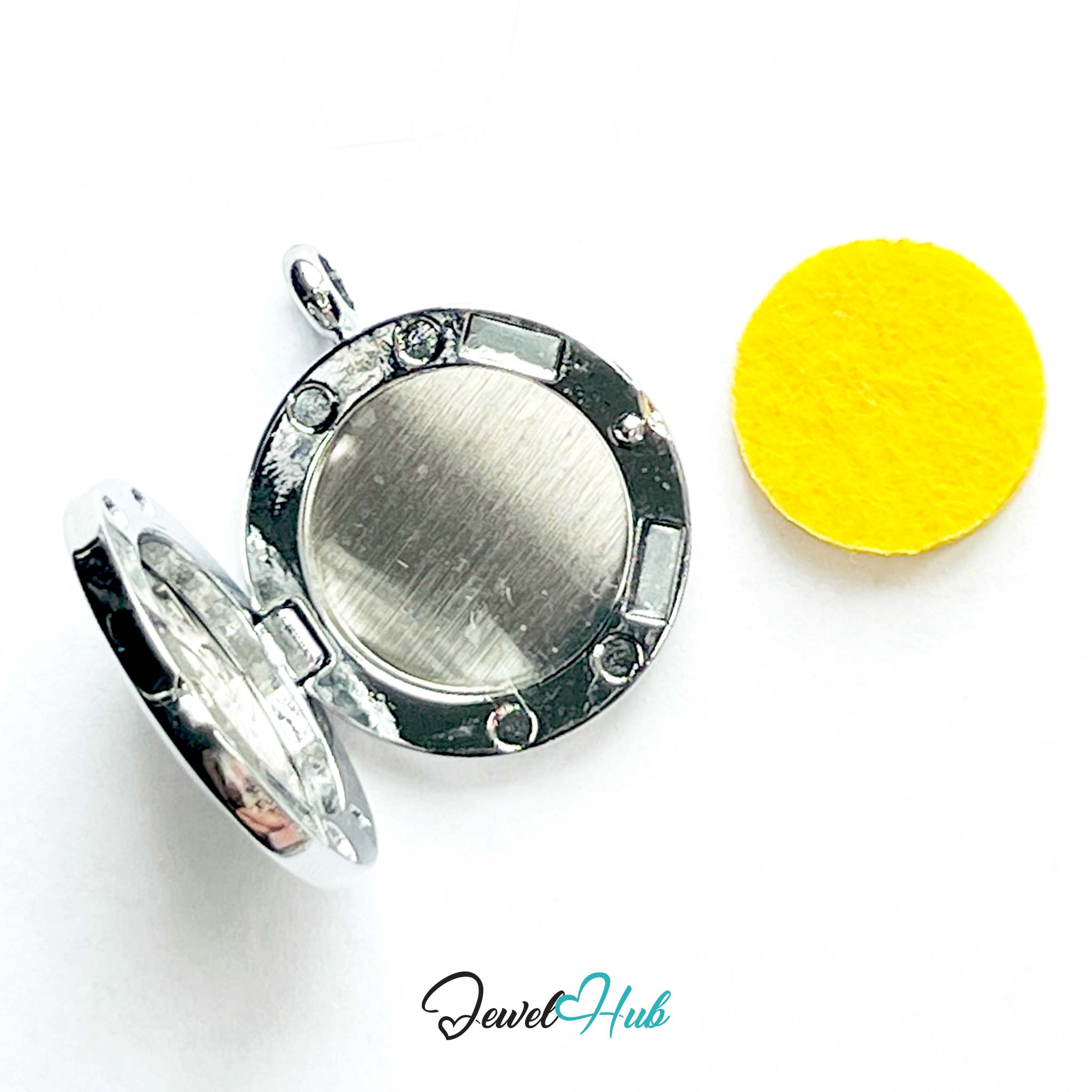 Silver locket with round face and decorative elements on a white background, with 'Jewel Hub' branding.