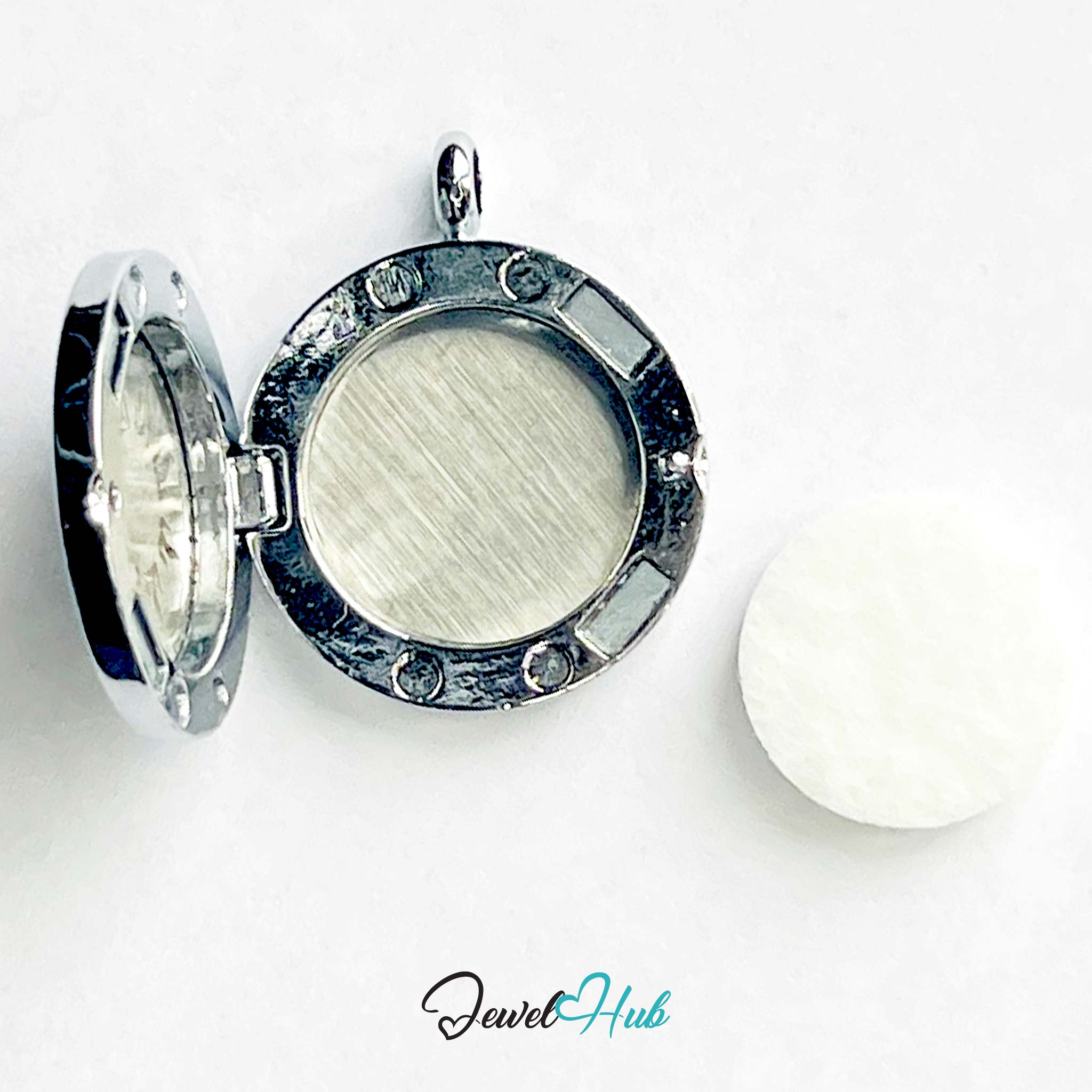 Silver locket with a white stone on a white background, branded 'Jewel Hub'.