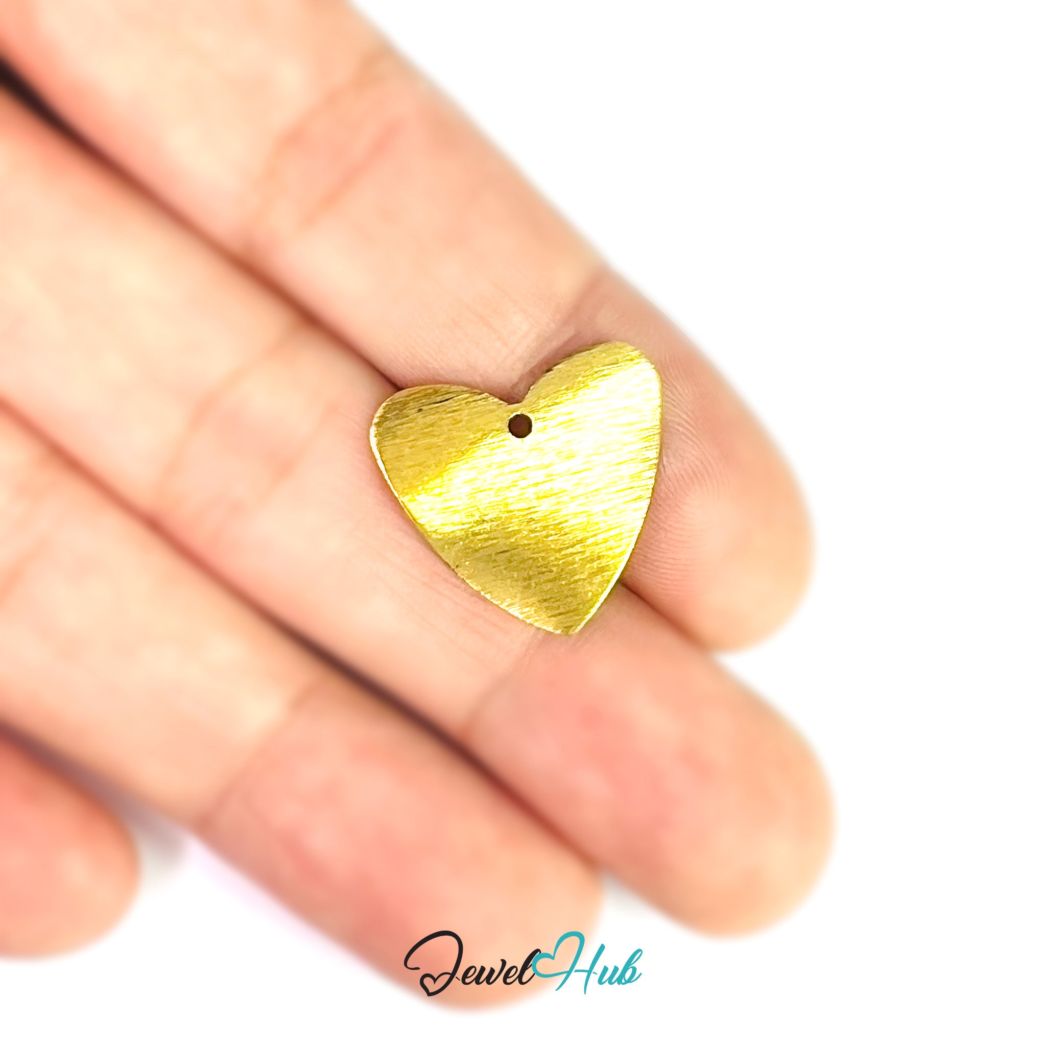 Gold heart-shaped pendant held between fingers on a white background with 'Jewel Hub' branding.