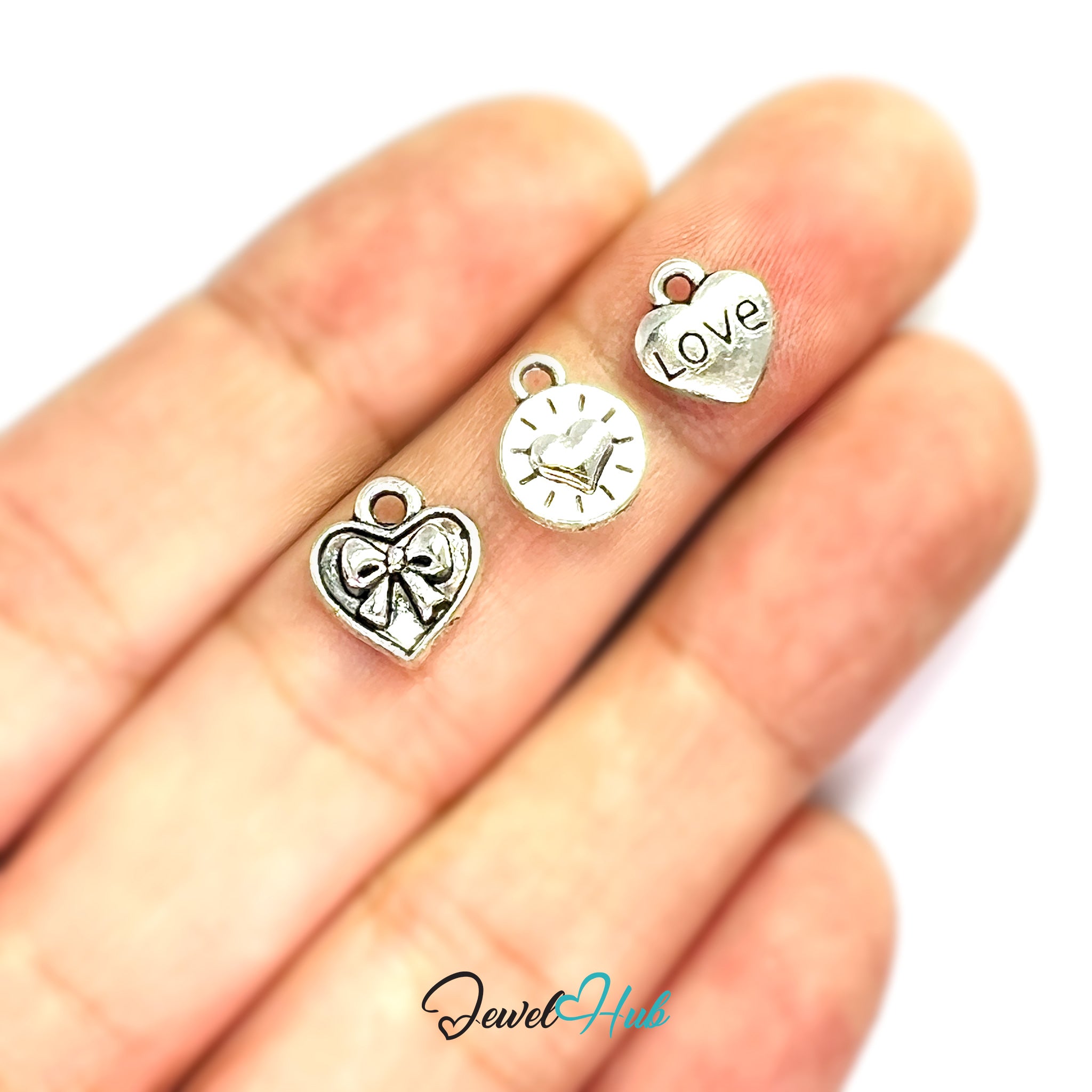 Three silver charms on a hand with 'Jewel Hub' branding.