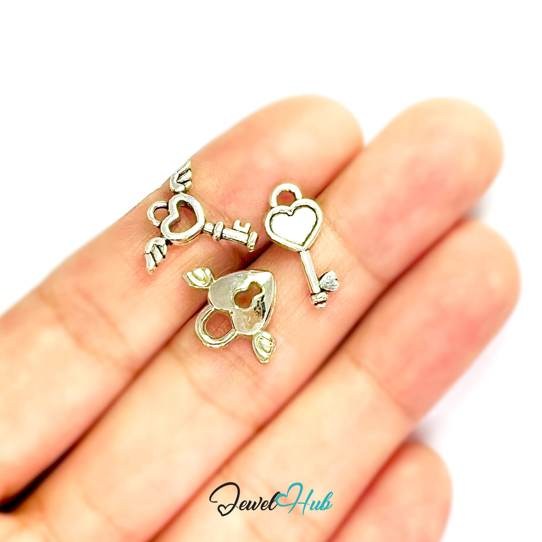 Three silver heart-shaped key pendants on a white background with 'Jewel Hub' branding.