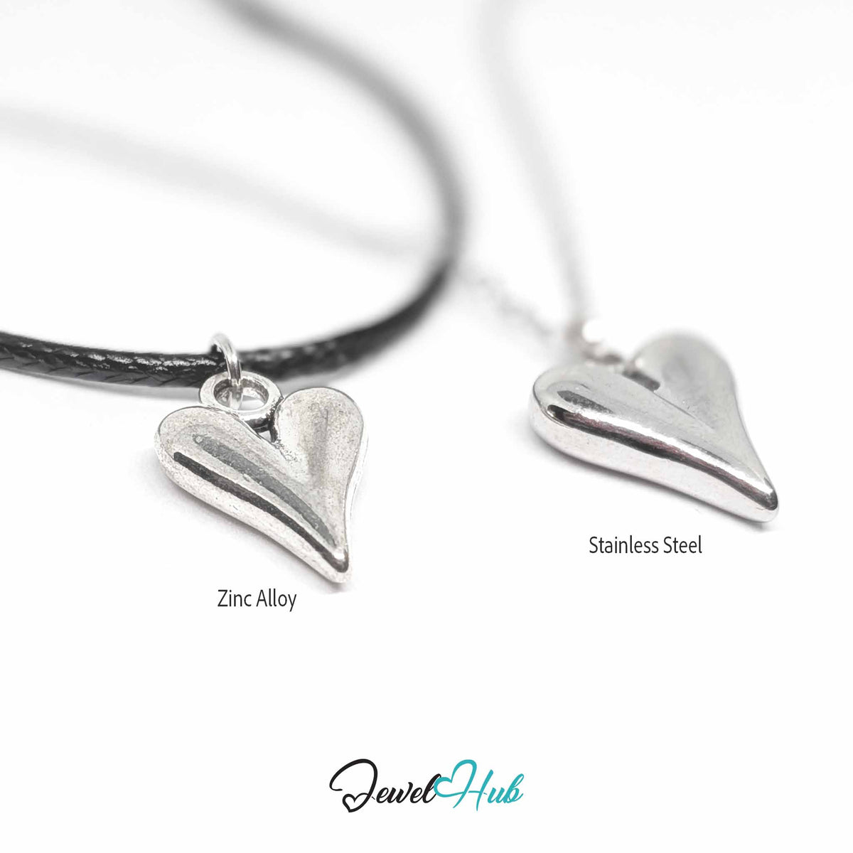 Angled view of zinc alloy heart pendant on cord and stainless steel heart pendant on chain, soft focus - JewelHub