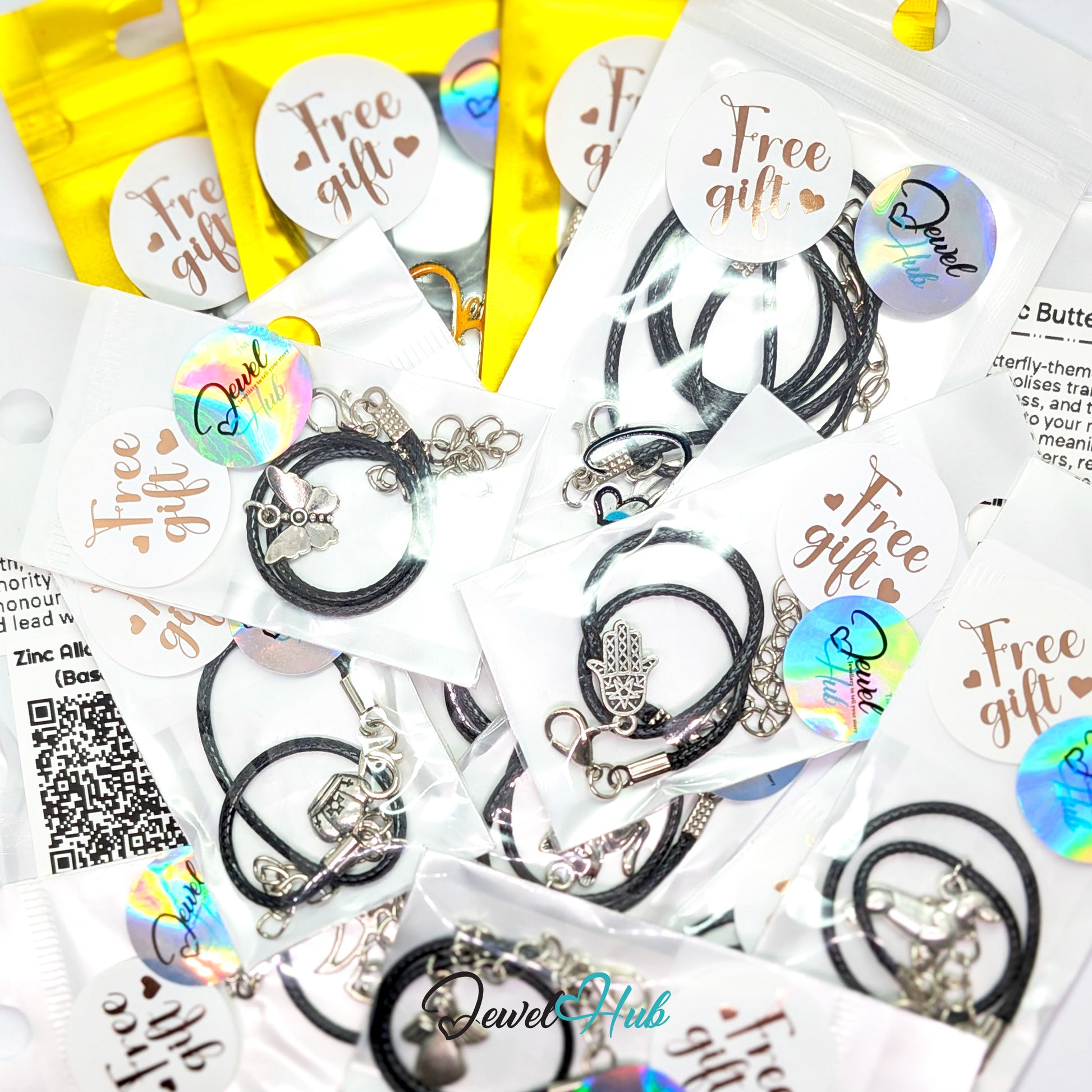 Stack of Free Gift bags with JewelHub stickers, black cord bracelets and a zinc alloy information card