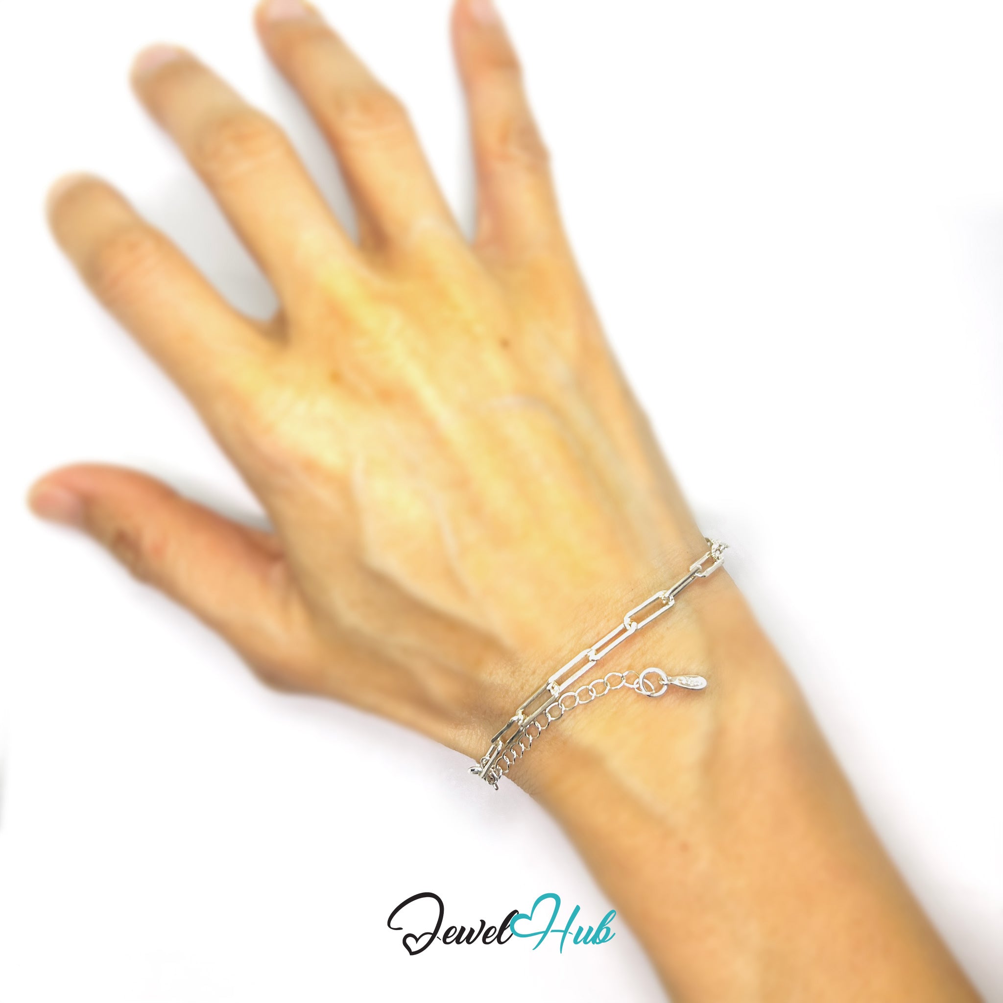 Hand wearing a silver bracelet on a white background with 'Jewel Hub' branding.