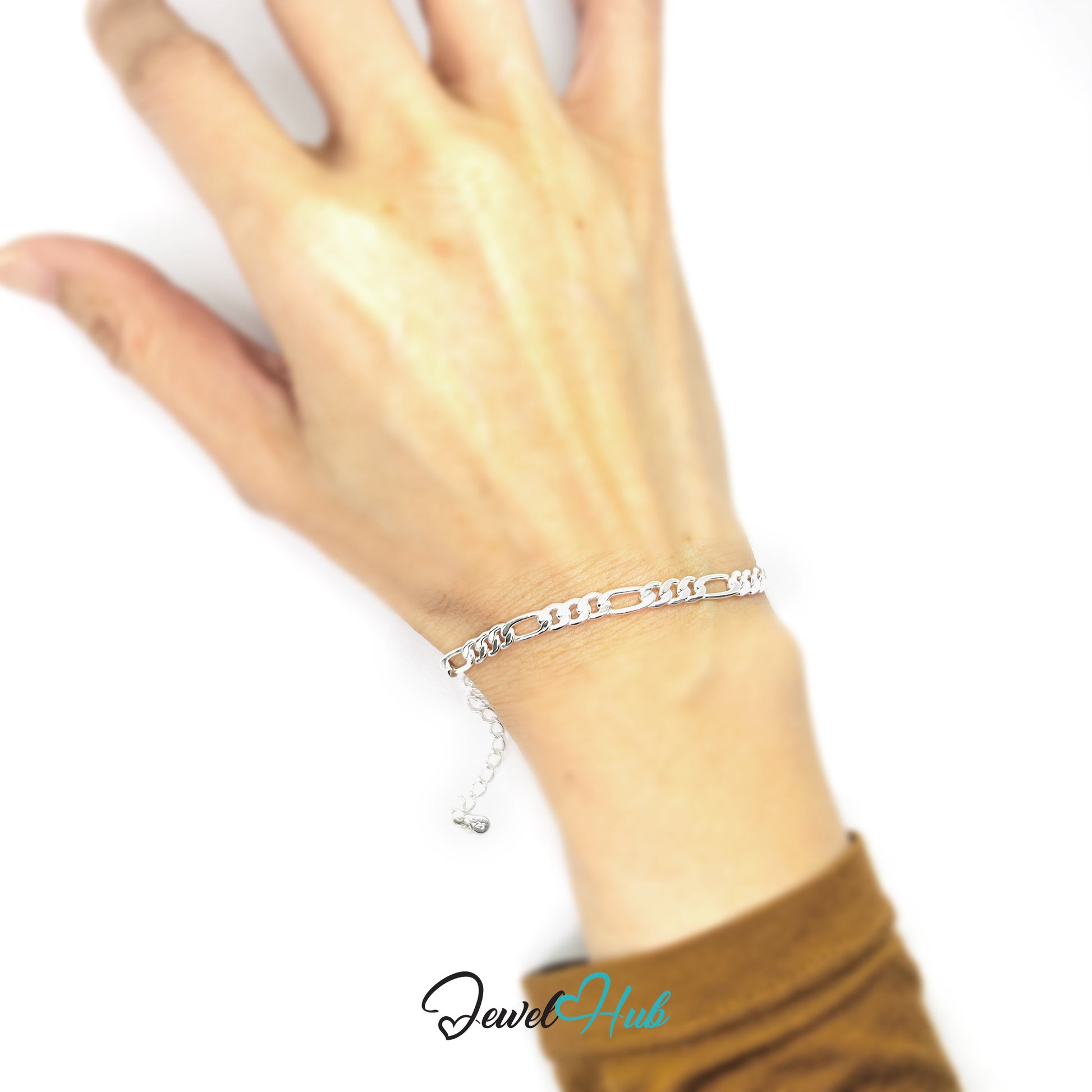 Silver bracelet on a wrist with a blurred background, featuring the brand 'Jewel Hub'.