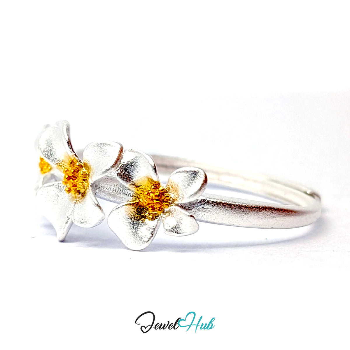 Three Flower Ring at an angle, showing the gold-tone flower centres and slim polished silver band