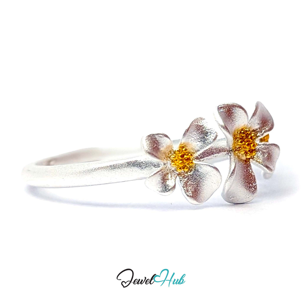 Close angle on two of the three brushed silver blooms and their gold-tone centres