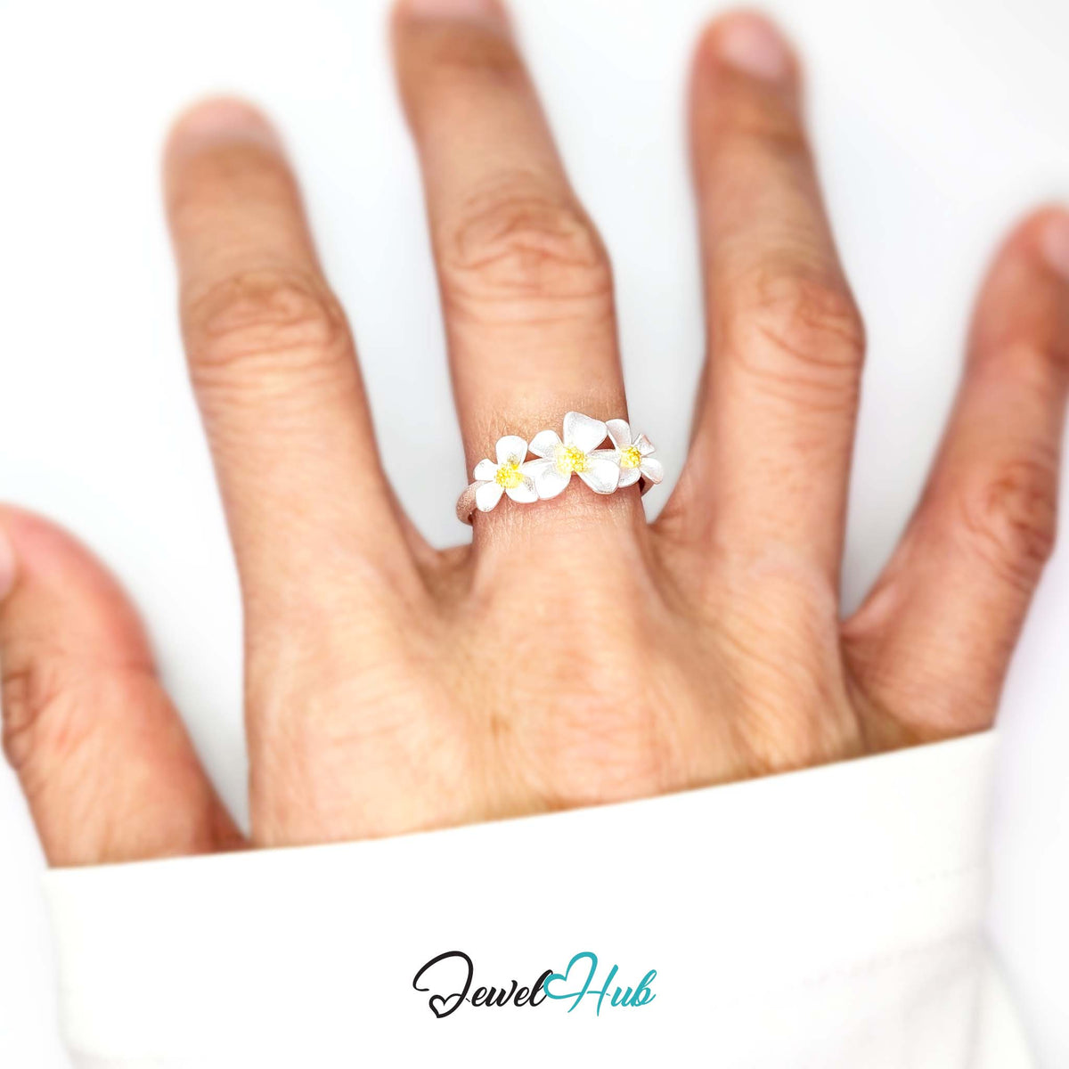 Three Flower Ring worn on a hand, showing the fit of the adjustable O-Q band