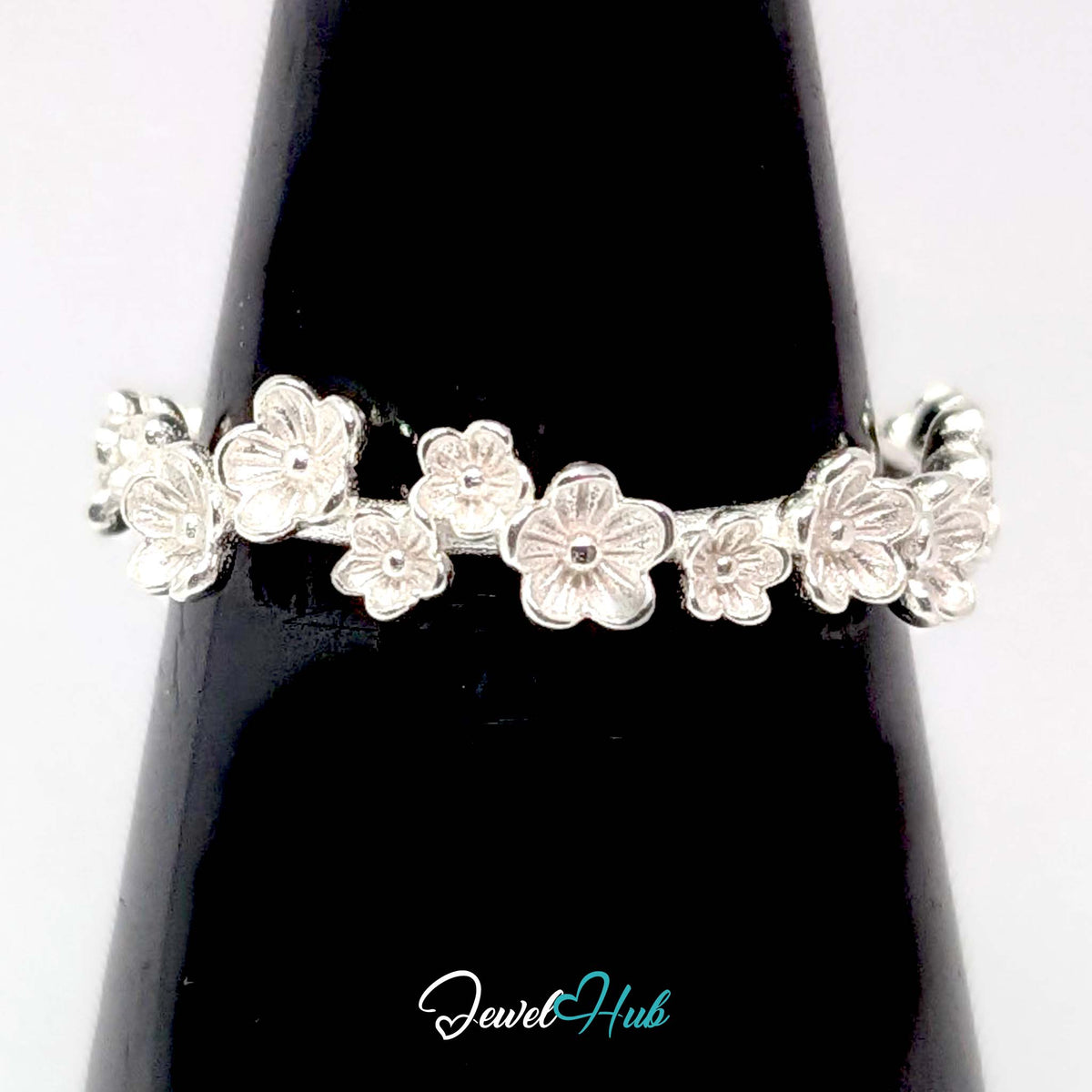 Blossom Band Ring displayed against a black cone, showing the matt flower detail
