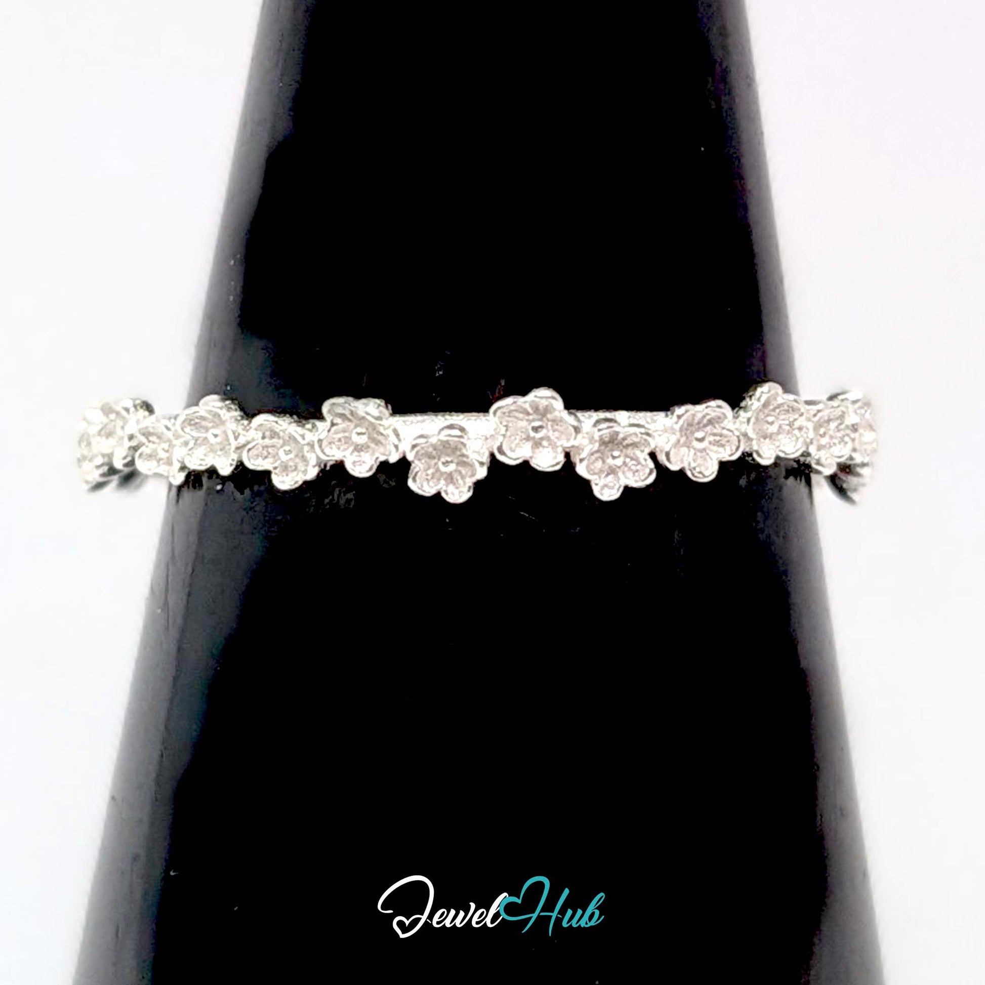 Mini Blossom Band Ring against a black cone, showing the slim blossom edge
