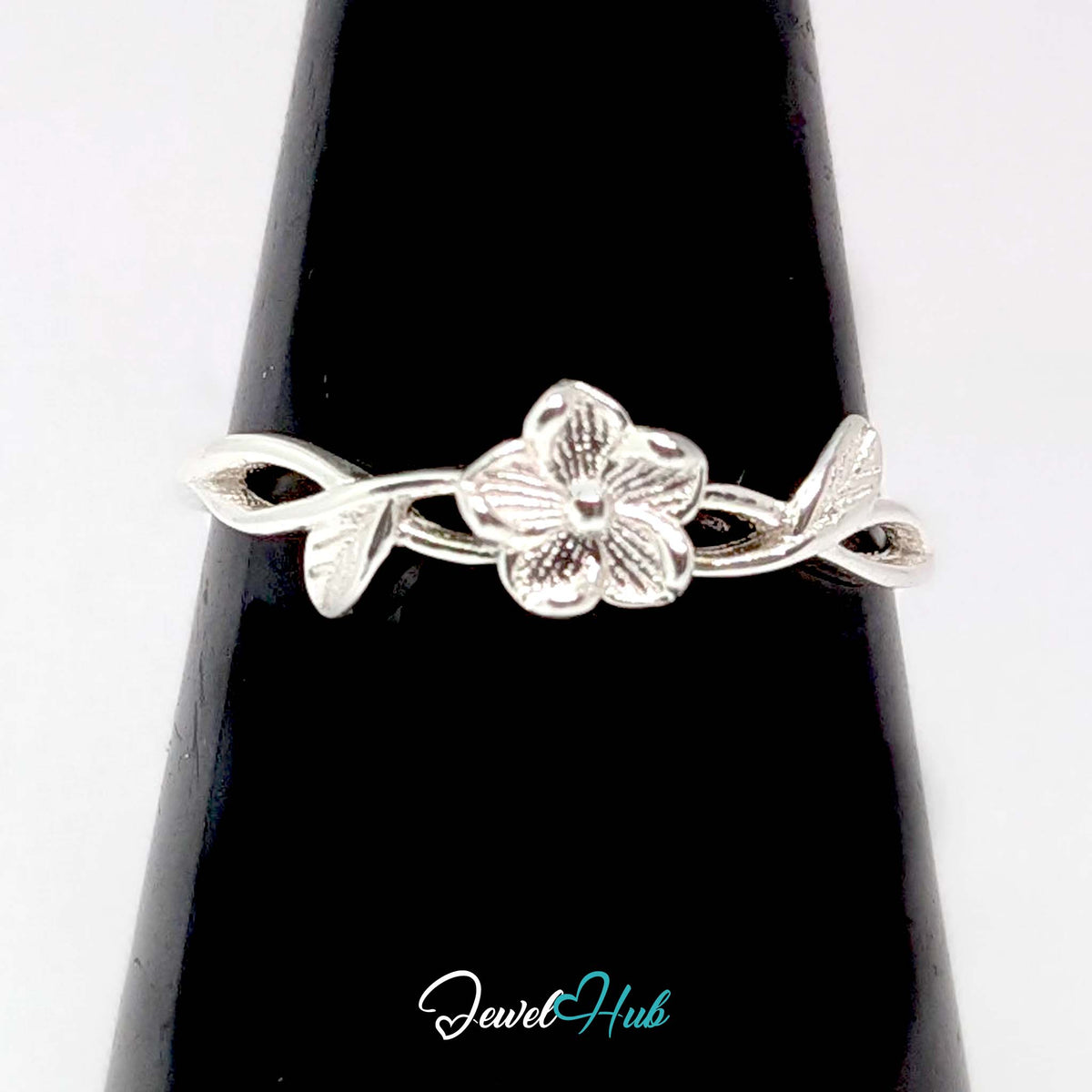 Peach Blossom Vine Ring against a black cone, showing the bloom and leaf detail