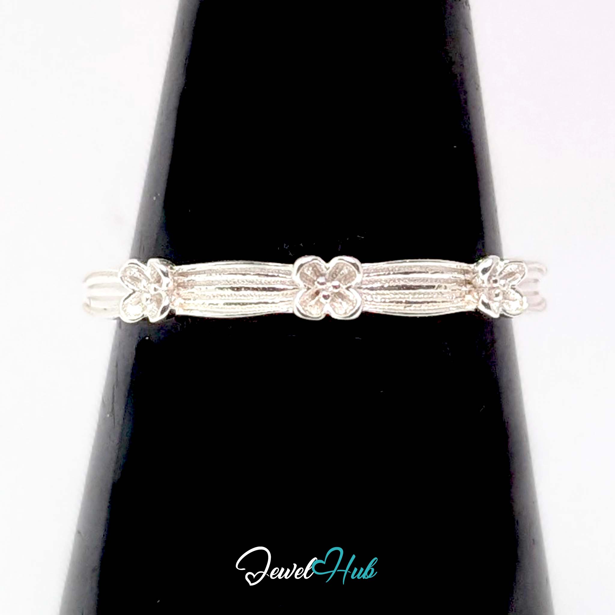 Flower Band Ring against a black cone, showing the ribbing and flower detail
